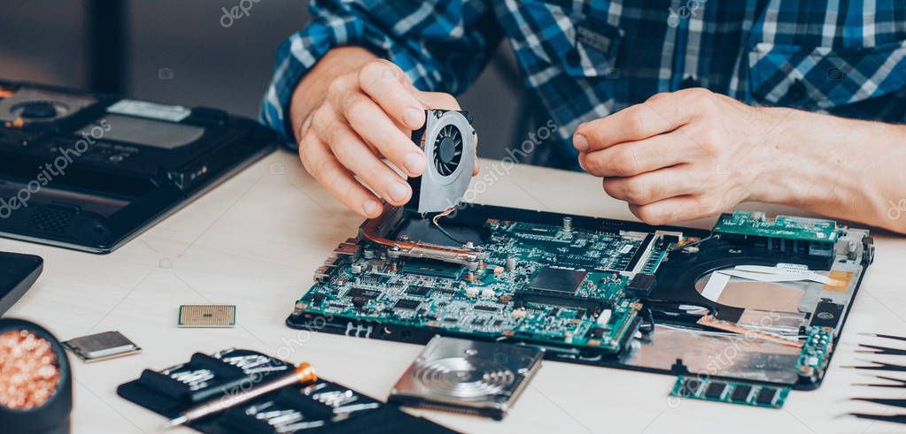 Technician repairing a desktop computer at a workbench
