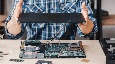 Technician inspecting an open laptop on a workbench