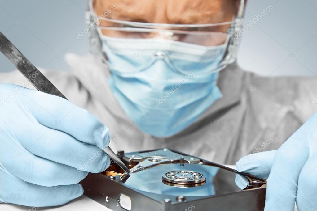 Computer technician connecting a hard drive for data recovery